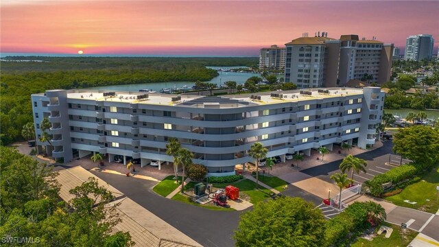 aerial view at dusk featuring a water view