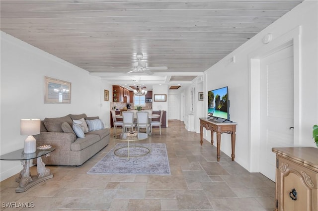 living room with stone tile floors, a ceiling fan, and baseboards