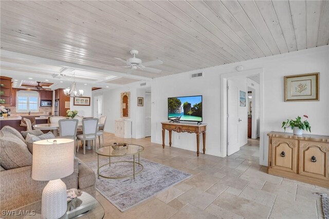 living room with ceiling fan with notable chandelier, wooden ceiling, and beamed ceiling