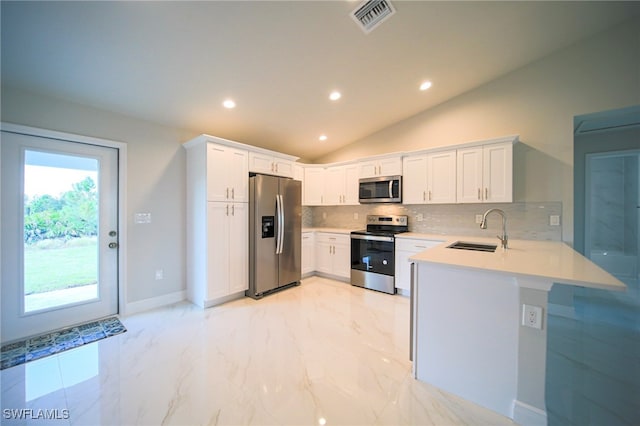 kitchen featuring stainless steel appliances, white cabinetry, lofted ceiling, and sink