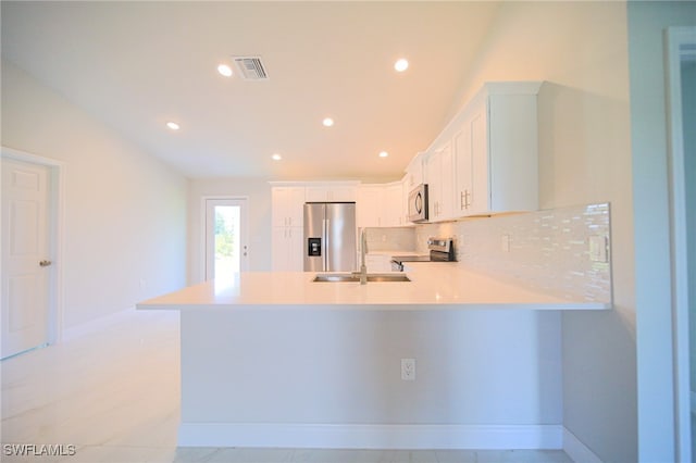 kitchen featuring white cabinetry, stainless steel appliances, kitchen peninsula, decorative backsplash, and light tile patterned floors