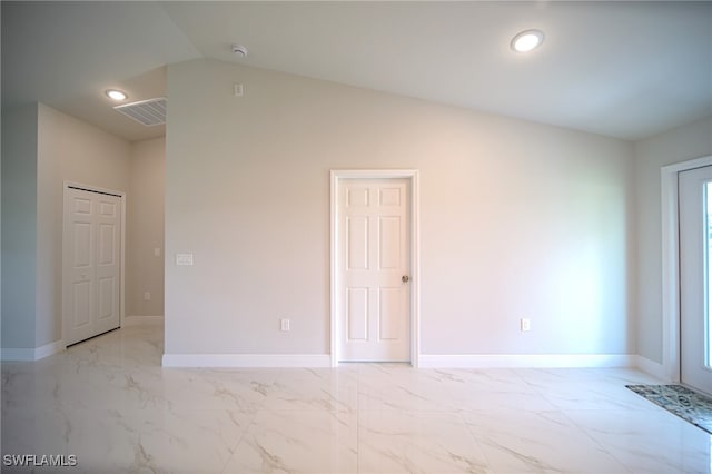 spare room with vaulted ceiling