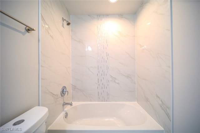 bathroom with tiled shower / bath combo and toilet