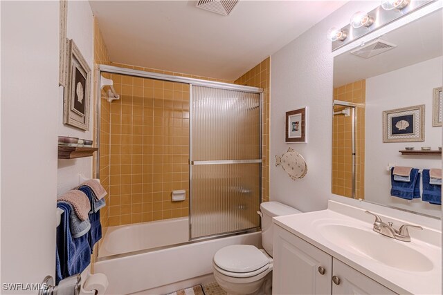 full bathroom with shower / bath combination with glass door, vanity, and toilet