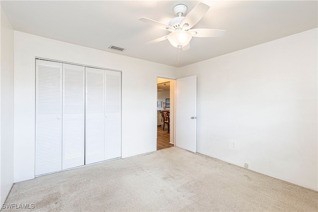 unfurnished bedroom with a closet, ceiling fan, and light colored carpet