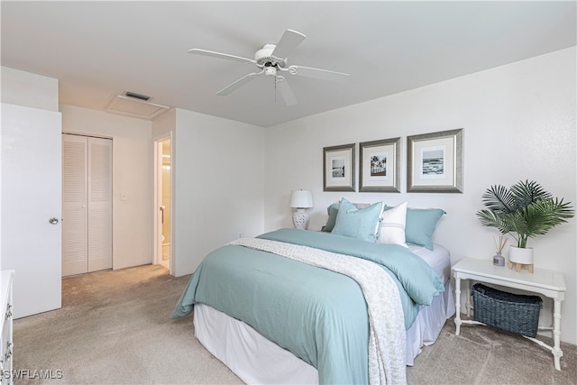 carpeted bedroom with a closet, ensuite bath, and ceiling fan