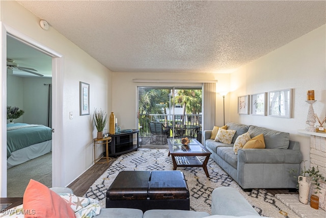 living room with ceiling fan, hardwood / wood-style floors, and a textured ceiling