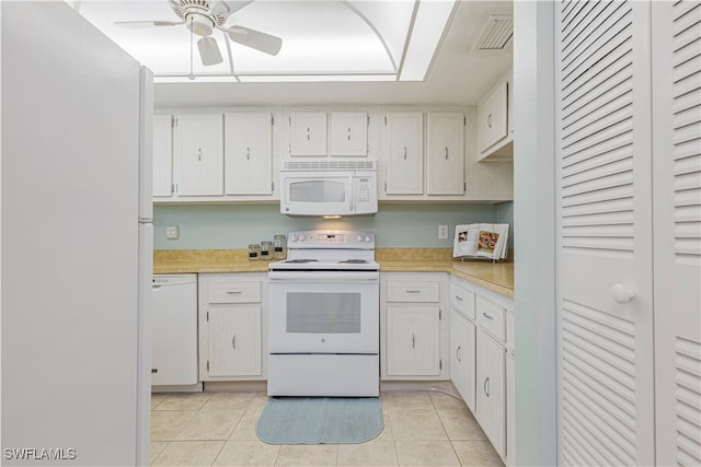 kitchen with white cabinets, light tile patterned flooring, and white appliances