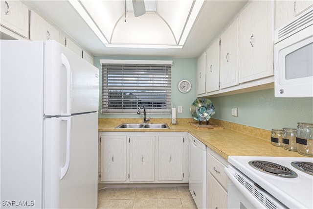 kitchen featuring sink, white cabinets, light tile patterned flooring, and white appliances