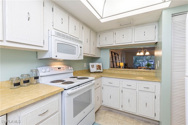 kitchen with white cabinets, light tile patterned floors, white appliances, and an inviting chandelier