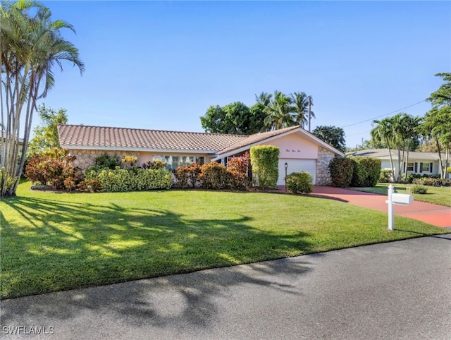 single story home featuring a garage and a front yard