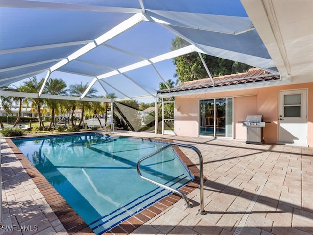 view of swimming pool with glass enclosure, area for grilling, and a patio area