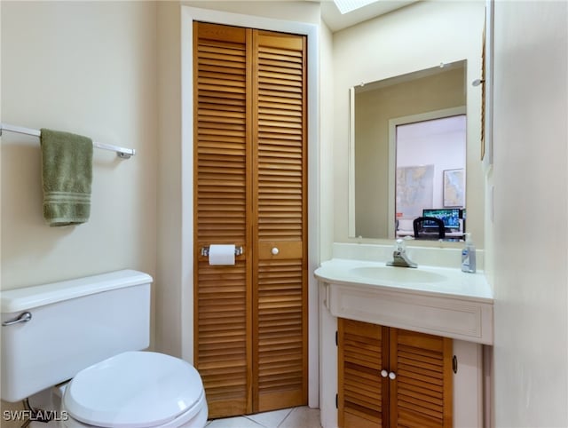 bathroom featuring tile patterned flooring, vanity, and toilet