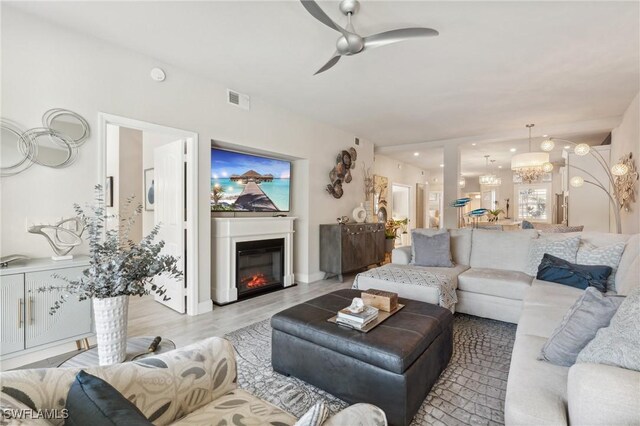 living room with light hardwood / wood-style floors and ceiling fan