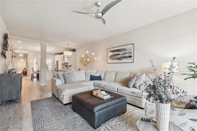 living room featuring light hardwood / wood-style floors and ceiling fan