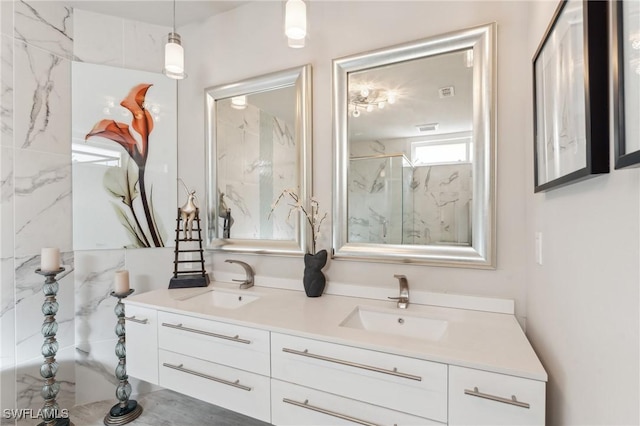 full bathroom featuring visible vents, a sink, a marble finish shower, and double vanity