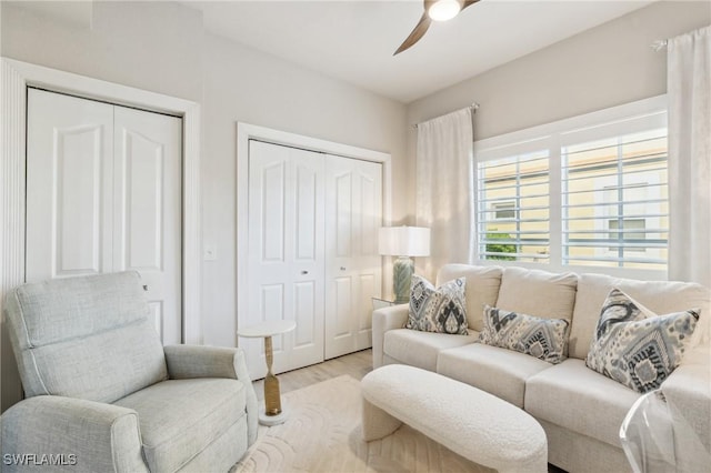 living area with light wood-style flooring and a ceiling fan