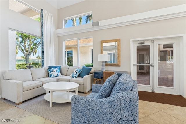 living area with a towering ceiling and light tile patterned floors