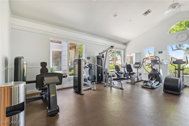 workout area featuring lofted ceiling, visible vents, and baseboards