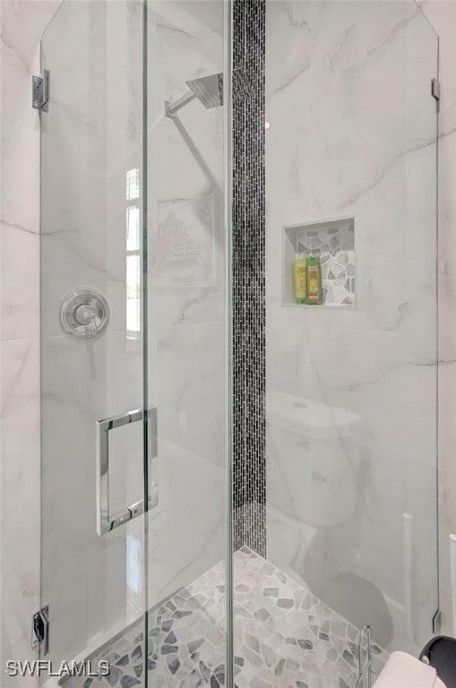 bathroom with a shower with door