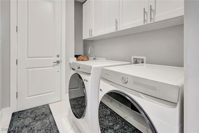 clothes washing area with cabinets, washing machine and dryer, and light tile patterned flooring