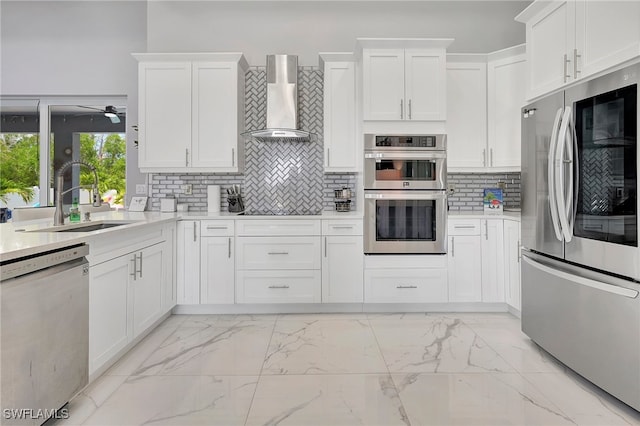 kitchen with white cabinetry, sink, stainless steel appliances, and wall chimney range hood