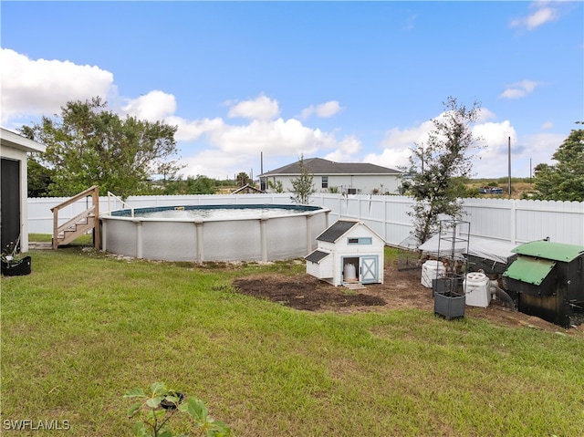 view of yard with a fenced in pool and a shed