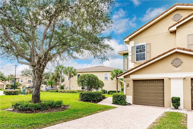 view of front of home with a garage and a front lawn