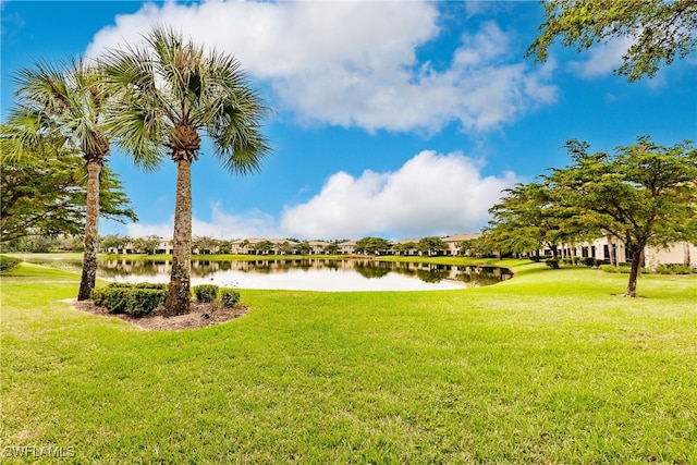 view of property's community featuring a lawn and a water view