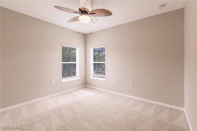 spare room with ceiling fan and light carpet