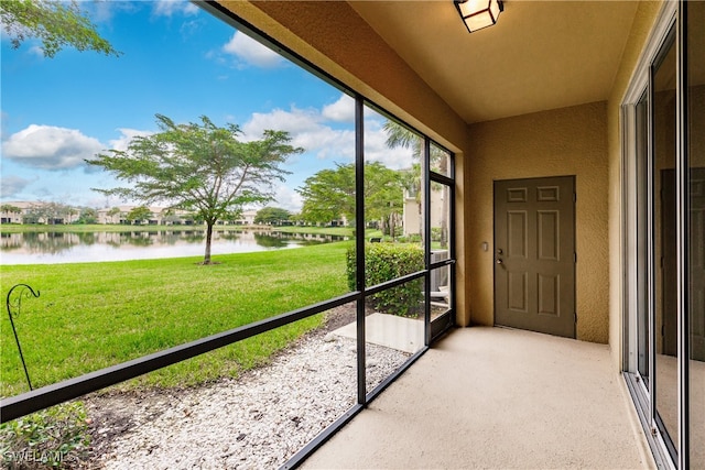 unfurnished sunroom featuring a water view