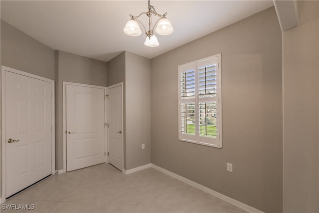 unfurnished bedroom featuring an inviting chandelier