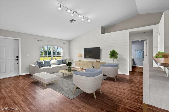 living room featuring track lighting, dark hardwood / wood-style flooring, and vaulted ceiling