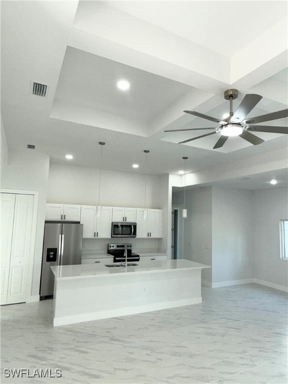 kitchen featuring sink, pendant lighting, a center island with sink, white cabinets, and appliances with stainless steel finishes