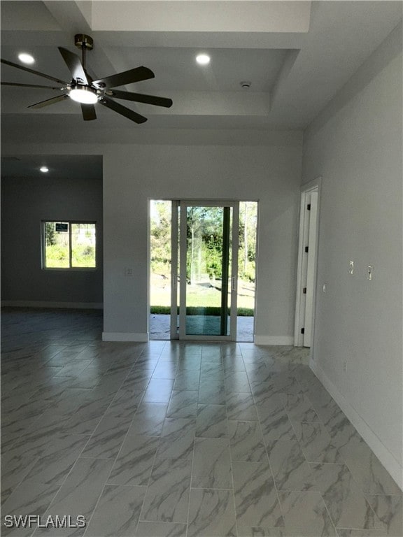 spare room featuring ceiling fan and a tray ceiling