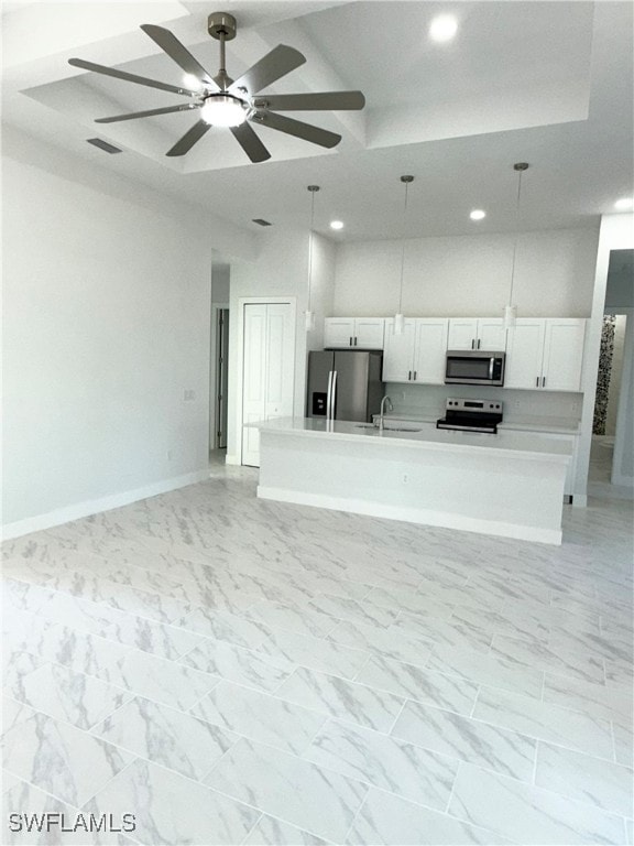 kitchen with appliances with stainless steel finishes, ceiling fan, sink, pendant lighting, and white cabinets