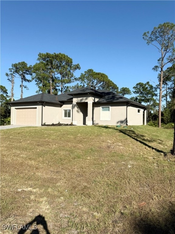 view of front of house featuring a garage and a front lawn