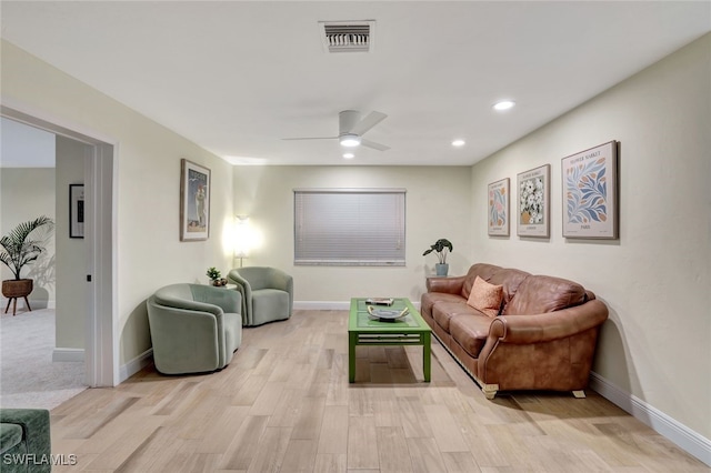 living room featuring light hardwood / wood-style flooring and ceiling fan