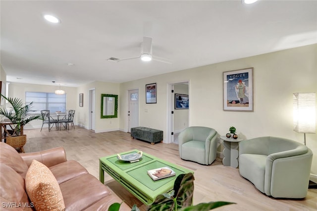 living room with ceiling fan and light wood-type flooring