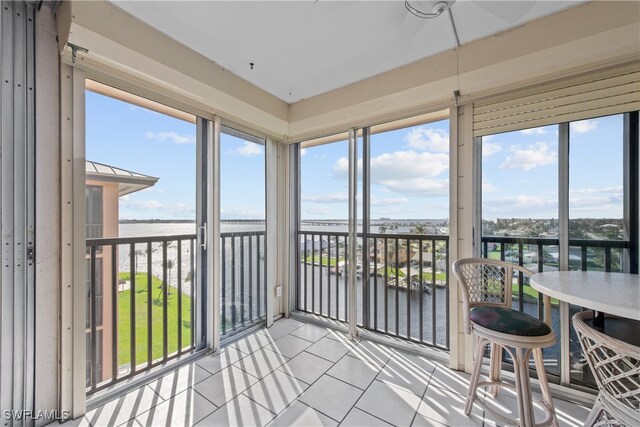 sunroom featuring plenty of natural light and a water view