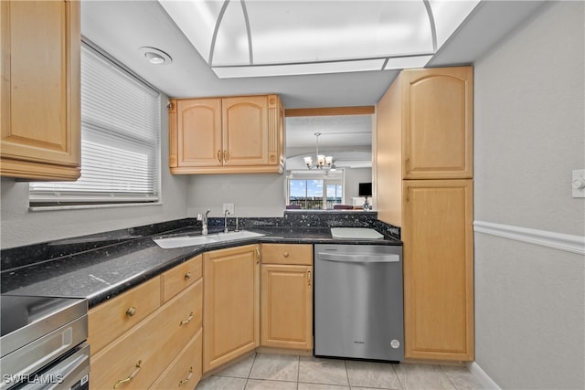 kitchen with dark stone counters, light brown cabinets, and stainless steel dishwasher