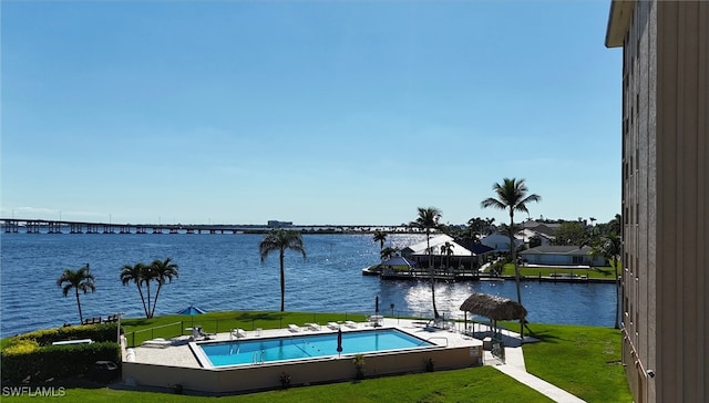 view of pool featuring a water view and a yard