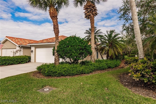 view of front of property featuring a front yard, an attached garage, stucco siding, concrete driveway, and a tiled roof