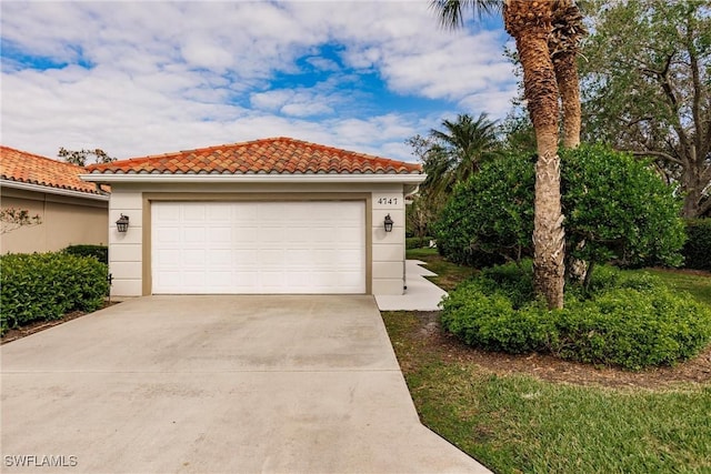 4747 San Carlo Ct, Naples, FL 34109 - view of front of home featuring a garage, concrete driveway, stucco siding, and a tiled roof