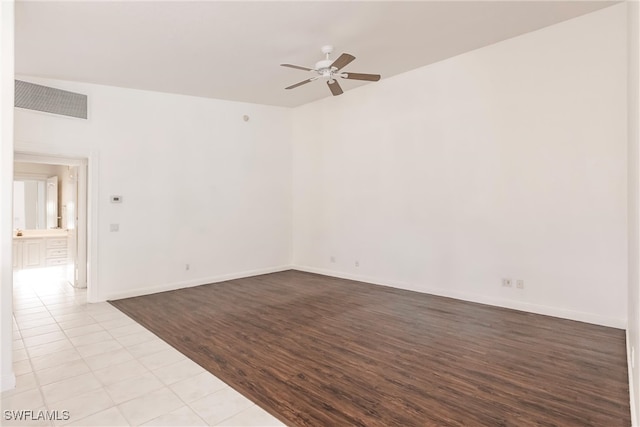 tiled spare room with ceiling fan