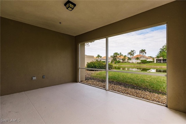 unfurnished sunroom featuring a water view and plenty of natural light