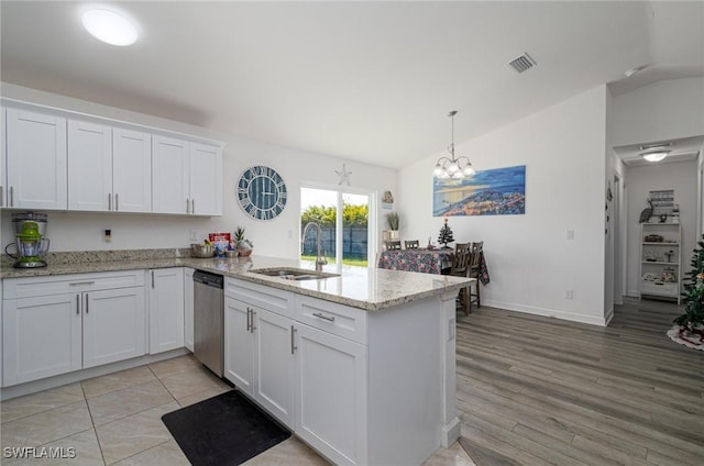 kitchen with a chandelier, white cabinets, vaulted ceiling, and stainless steel dishwasher