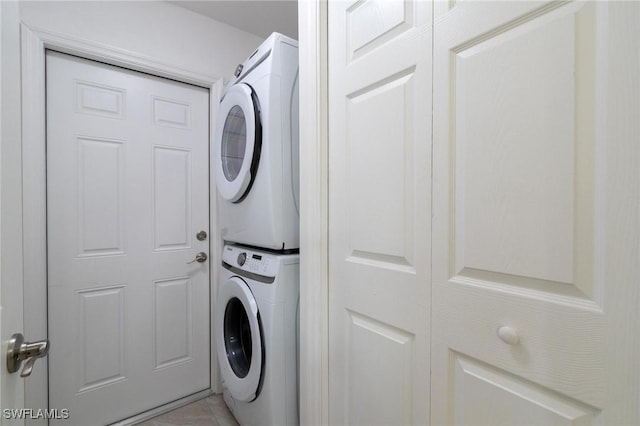 clothes washing area featuring stacked washer and dryer