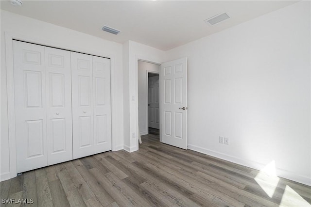 unfurnished bedroom with a closet and light wood-type flooring