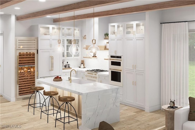 kitchen featuring sink, light wood-type flooring, white cabinets, a center island with sink, and wine cooler